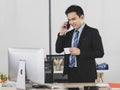 Asian adult businessman is office people very handsome and smart wearing black suit standing at work desk do determined to talking