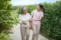 Asian adult daughter hug her senior mother in backyard garden  at home . young woman embrace old mom  to take care in park Royalty Free Stock Photo