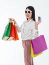 Asian adult smiley woman wearing fashion sunglasses, holding colorful paper bags, showing credit card for payment, presenting Royalty Free Stock Photo