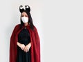 Asian adult woman wear hygiene face mask and vampire cloak costume fashion in clasp hand gesture with confident pose for Horror Royalty Free Stock Photo