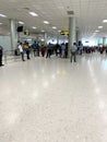 Asian airlines passengers with luggage waiting for check-in through airport building, aircraft flights on electronic scoreboard,