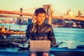 Young Asian American college student working on laptop computer outddors by river in New York City Royalty Free Stock Photo