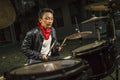 Asian American mixed teenager playing drums at home garden . cool and handsome young boy practicing on drum kit rehearsing Royalty Free Stock Photo