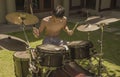 Asian American teenager playing drums. Summer portrait of handsome young boy practicing on drum kit at home garden rehearsing rock Royalty Free Stock Photo