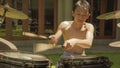 Asian American teenager playing drums. Summer portrait of handsome young boy practicing on drum kit at home garden rehearsing rock Royalty Free Stock Photo