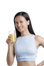 Asian American Woman drinking a glass of Orange Juice Royalty Free Stock Photo