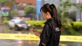 Asian American Woman Police Officer at Crime scene, side view,