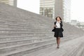 asian appearance business woman walk along stairs speaking