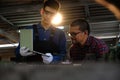 Asian apprentice young engineer discussion with a technician on the job while holding a laptop in hand, Studying machine