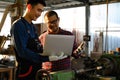 Asian apprentice young engineer discussion with a technician on the job while holding a laptop in hand, Studying machine