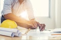 Asian architect man Standing working with blueprints sketching.t home office.Construction Royalty Free Stock Photo