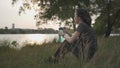 Asian athlete woman in green nature tree park and lake in evening sunset feeling thirsty drink water from bottle. energy drinks