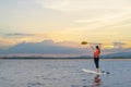 Asian athletic woman on stand paddle board in lake. Solo outdoor SUP activity and water sport on summer