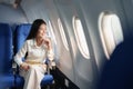 Asian attractive business woman passenger sitting on business class luxury plane while relax while travel concept Royalty Free Stock Photo