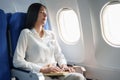 Asian attractive business woman passenger sitting on business class luxury plane while relax while travel concept Royalty Free Stock Photo