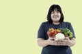 Asian attractive fat woman holding glass bowl  contains fruit and fresh vegetables Royalty Free Stock Photo