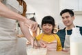 Asian attractive LGBTQ gay family teach girl kid making yeast dough. Handsome male couple take care and spend time with little