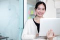 asian attractive mature businesswoman smiling looking at camera typing working on laptop in office. Successful female information Royalty Free Stock Photo