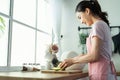 Asian attractive woman wear apron cook green salad in kitchen at home. Young beautiful girl feeling happy and enjoy eating Royalty Free Stock Photo