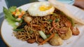 Asian authentic fried noodle with meat ball, veggie, shrimp crisp and egg in a plate