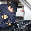 Asian auto mechanic checking the car using tablet