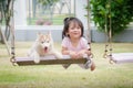 Asian baby baby on swing with puppy Royalty Free Stock Photo