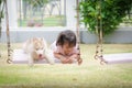 Asian baby baby on swing with puppy Royalty Free Stock Photo