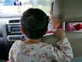 Asian baby being complained by her mother for not sitting and fastening the safety belt properly