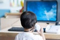 Asian Baby  boy with black hair talking to telephone in front of computer laptop notebook Royalty Free Stock Photo