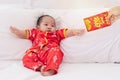 Asian baby boy Chinese Cheongsam costume toddler lie down on bed at home smiling laughing good humored infant Chinese boy laugh