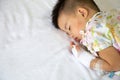 Asian baby boy sleeping on bed with infusion set at child department in the hospital. Royalty Free Stock Photo