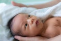 Asian baby boy smiling and feeling happy after taking bath. mother dries and rubs her newborn baby hair and head with a towel Royalty Free Stock Photo