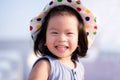 Asian baby child girl beaming smiling. Close up happy face. Little girl wearing white hat. Half body photo. She has tooth decay. Royalty Free Stock Photo