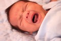 Asian baby crying on bed. Royalty Free Stock Photo