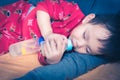 Asian baby drinking milk from bottle Royalty Free Stock Photo
