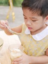 Asian baby girl enjoy trying new food by herself, soft-boiled eggs