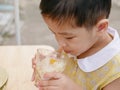 Asian baby girl enjoy trying new food by herself, soft-boiled eggs