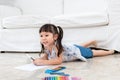 Asian baby girl Lying on the floor,  are concentrating make art by using colored pencil Royalty Free Stock Photo