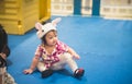 Asian baby girl playing in childrens playground indoors, kid plays