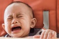 Asian baby girl sitting in highchair and crying refuses to eat f Royalty Free Stock Photo