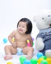 asian baby girl smiling and sitting is playing with colorful ball isolated on white background Royalty Free Stock Photo