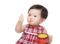 Asian baby girl with snack box and thumb up Royalty Free Stock Photo