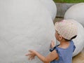 Asian baby girl touching a dinosaur egg to explore if she feels anything inside