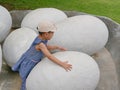Asian baby girl touching a dinosaur egg to explore if she feels anything inside