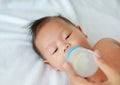 Asian baby infant drinking milk from bottle Royalty Free Stock Photo