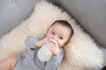 Asian baby infant eating milk from bottle, 9 months after birth Royalty Free Stock Photo