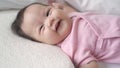 Asian baby infant laying down on white soft bed happy and smile. 3 months old baby facial expression