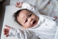 Asian baby infant in white lie down on bed with face expression. facial expression in baby Royalty Free Stock Photo