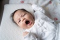 Asian baby infant in white lie down on bed with face expression. facial expression in baby Royalty Free Stock Photo