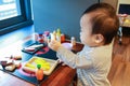 Asian baby playing alone with toy kitchen kit Royalty Free Stock Photo